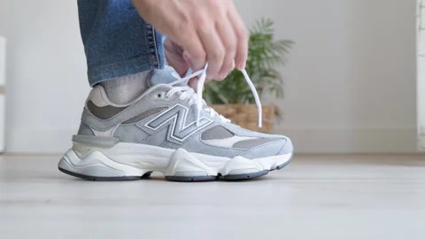 Side profile of a grey suede New Balance 9060 sneaker on a foot in jeans Video stock 313278284