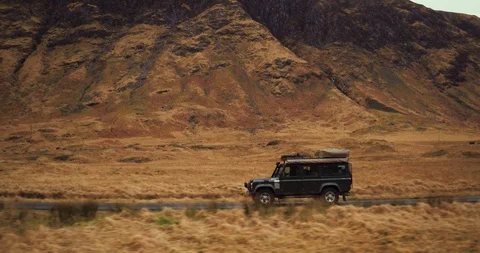 Side profile of Land Rover Discovery in mountainous environment drone aerial 4K Stock Footage 104583653