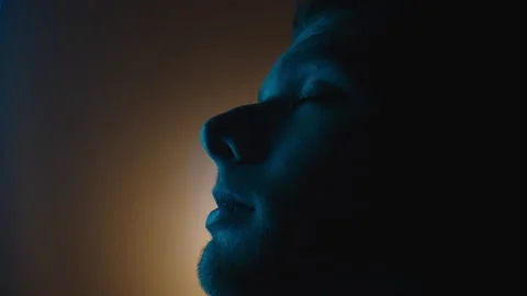 Side Profile of Man Looking Up with Colourful Lights Video stock 154146368