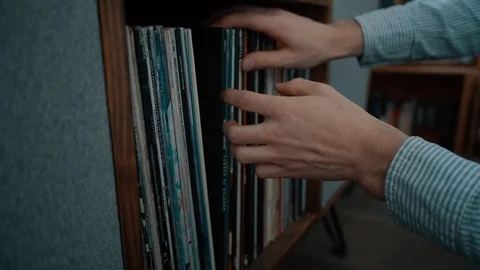 Side profile of mans hands choosing a record to play. 스톡 동영상 121865923