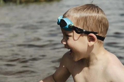 A side profile shot of a young boy in a natural water setting. He is wearin.. 写真素材