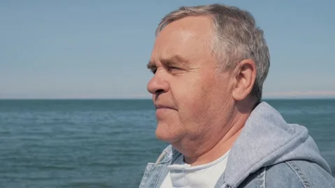 Side profile of thoughtful senior man gazing at sea Stock Footage 267909494