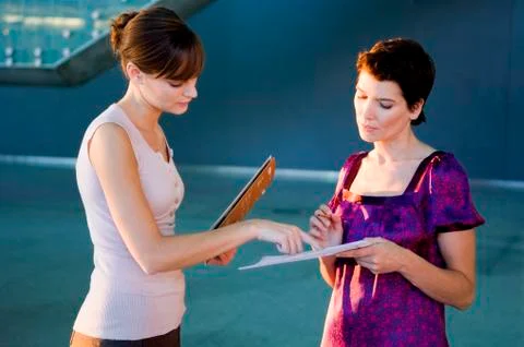 Side profile of two interior designers discussion on a blueprint Stock Photos