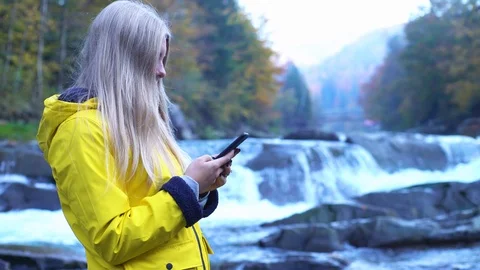 Side profile view of gorgeous pretty young girl in yellow raincoat using her Stock Footage 119512808