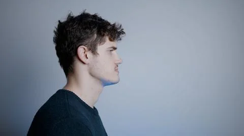 Side Profile of Young Dark-Haired Man Looking Out of Frame Stock Photos