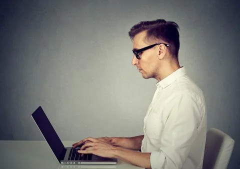 Side profile young man using a laptop computer Stock Photos