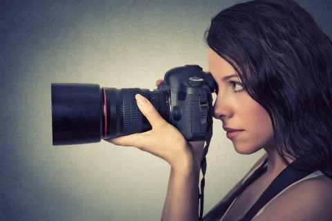 Side profile young woman taking pictures with professional camera Stock Photos