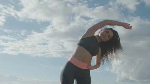 Side reach exercises. Stretching and warm-up. Girl exercises by the sea Stock Footage 108471132