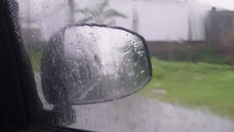 Side rear view mirror of a car driving,   heavy rain conditions Stock Footage 223058403