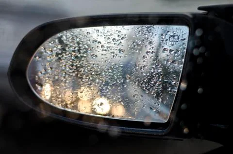 Side rear-view mirror in the evening on the road during sunset Stock Photos