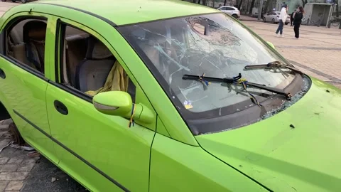 On the side of the road is a destroyed, burned-out civilian car. War in Ukraine Stock Footage 233691054