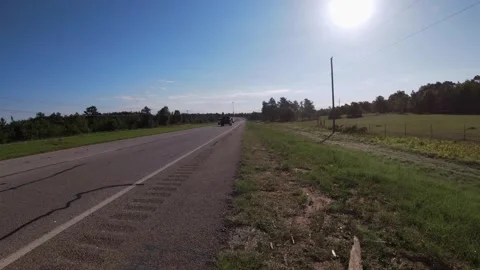 Side of the road view Traffic on a rural country highway with the sun beaming Stock Footage 158122067
