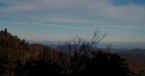 Side scrolling shot of mountains with trees in the foreground 4k Stockbeeldmateriaal 144428202
