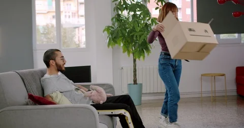 Side shoot of happy girlfriend finished unpacking belongings sitting on sofa Stock Footage 123666541