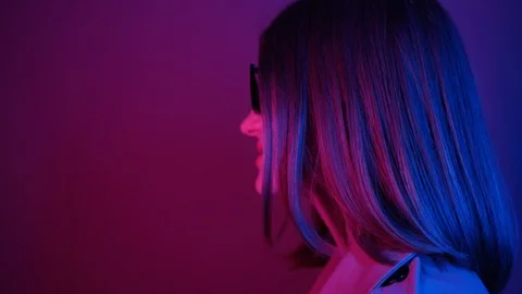 Side shooting of cute happy young woman in black sunglasses, looking at camera Stock Footage 119547984