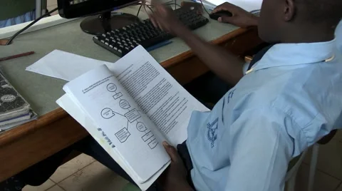 Side shot of African students using book and computer at school-Education Africa Stock Footage 58974673