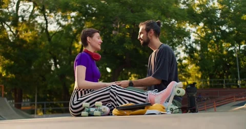 Side shot of a brunette guy in a gray t-shirt and a short-haired girl in a Stock Footage 250243251