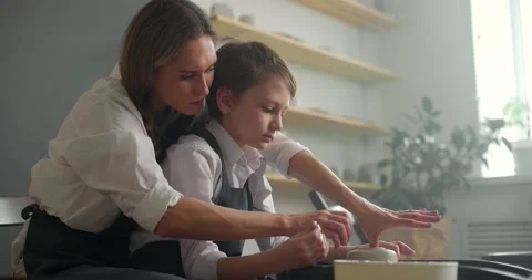 Side shot of child boy and his mother working on a pottery master class. Happy Stock Footage 155815352