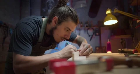 Side shot close up of serious carpenter luthier male working in workshop evening Stock Footage 137244736