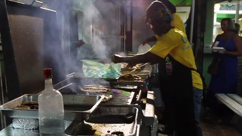 Side Shot of Cooks Grilling Fish at Oistins in Barbados Stock Footage 105994220