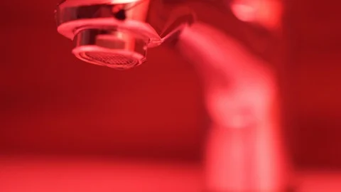 Side shot of dripping tap. Red light, seamless Stock Footage 106437495