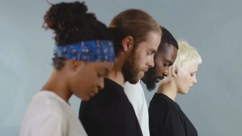 Side shot of group of people of different races lowered their heads black white Stock Footage 133640904