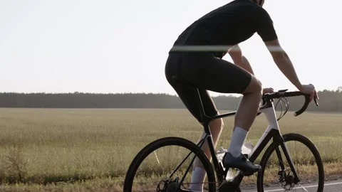 Side shot of man riding a road bike at the sunset on a highway, wearing helmet Vídeo Stock 166174052
