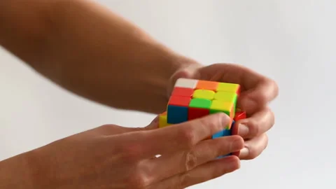 Side shot of a man solving a Rubik's Cube quickly Stock Footage