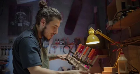 Side shot of positive artisan in apron working with planks fixed in wood straps Stock Footage 137241415