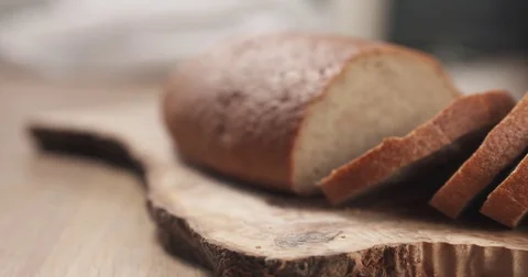 Side shot of slices of rye wheat rustic bread on cutting board Stock Footage