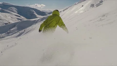 Side shot of a snowboarder pulling powder spray in the air while riding a Video stock 147375813