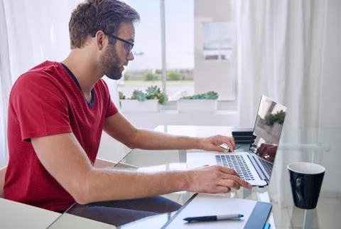 Side shot of student working at desk from home Stock-Fotos