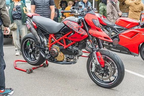 Side-by-side image of two red motorcycles, one a Ducati with intricate design Stockfoto's