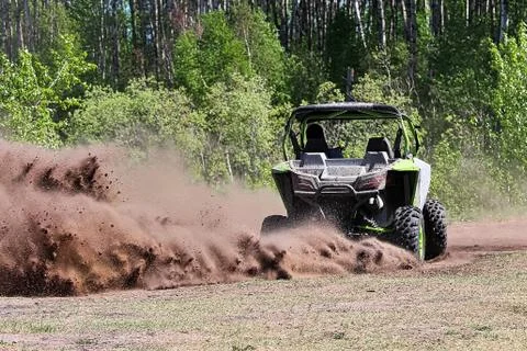 A side-by-side ripping up dirt as it turns a corner Stock Photos
