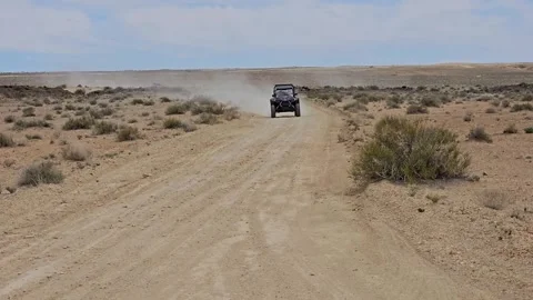 Side by Side off road vehicle approaching-dusty desert road Stock Footage 243840170