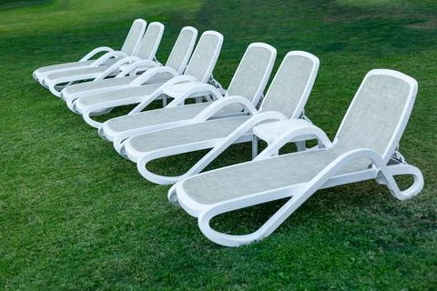 Side by side rows of white sun loungers Photos
