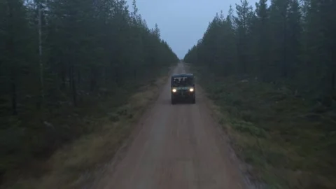 Side by side UTV races through dirt road in foggy pine tree forest with Stock Footage 244762607