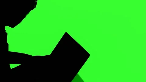 Side Silhouette of Person Using Laptop on Green Screen for Video Editing Stock Footage 316239244