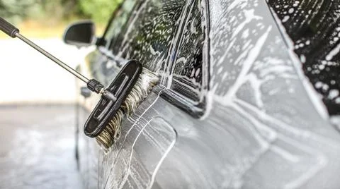 Side of silver car washed in self service carwash, detail on brush moving ove Stock Photos