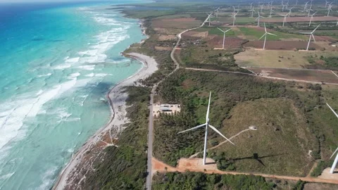Side slow drone footage of a Beautiful Wind Farm Next to the Serene Beach Stock Footage 234407878