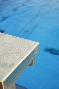 The side of the starting block in the pool against the background of blue wat Stock Photos