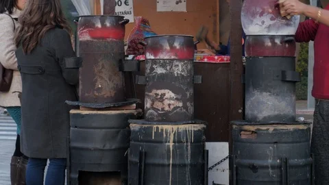 Side static shot of an outdoor stall selling grilled chestnuts. Stock Footage 121786866