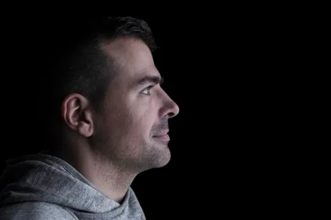 Side studio portrait of a serious man looking sideways. Stock Photos