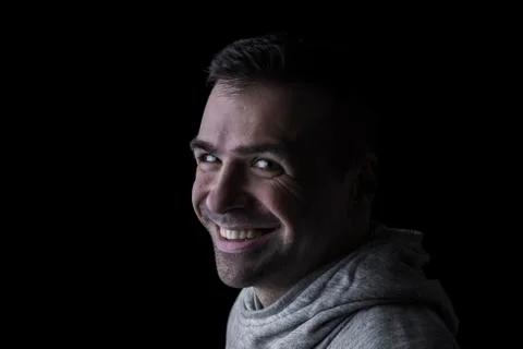 Side studio portrait of a smiling man looking at the camera. Stock Photos