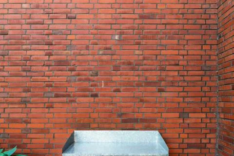 Side table in front of a red brick wall Stock-Fotos