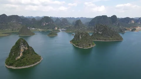 Side Tracking Drone Shot Across Karst Islands Rising from Blue Lake Guangxi Stock Footage 330281696