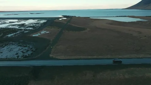Side tracking shot of a car driving on a coastal road in Iceland Vídeo Stock 332657151