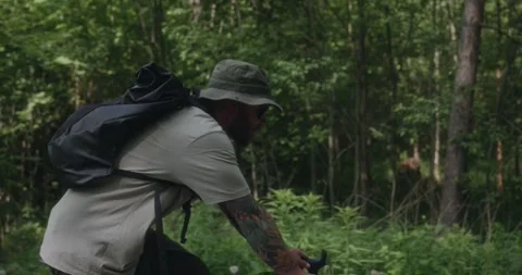 Side tracking shot of cyclist in green forest Stock Footage 312354873