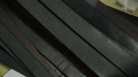 Side tracking shot of leather belts arranged in one direction Stock Footage 312258847