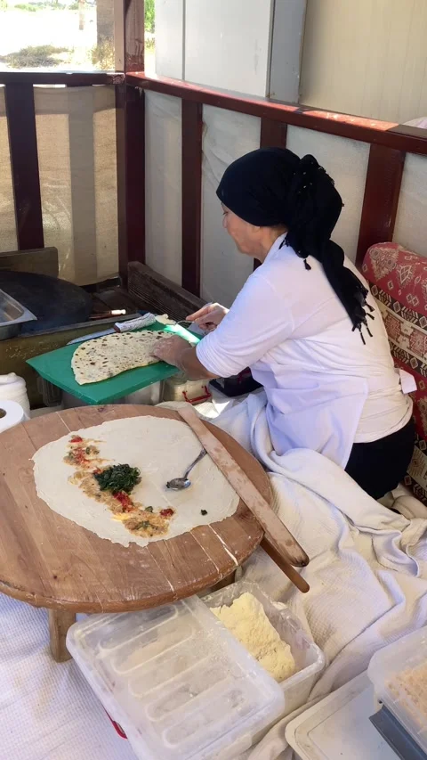 Side, Turkey, June 30, 2025. A woman makes traditional Turkish stuffed flatbread Stock Footage 314972174